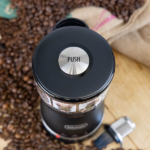 The push button on top of a DeLonghi coffee grinder.