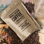 Toasted nut fudge coffee beans in a brown sealed bag.