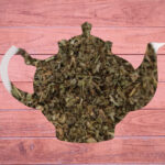 Dark green loose leaf tea in the shape of a teapot.
